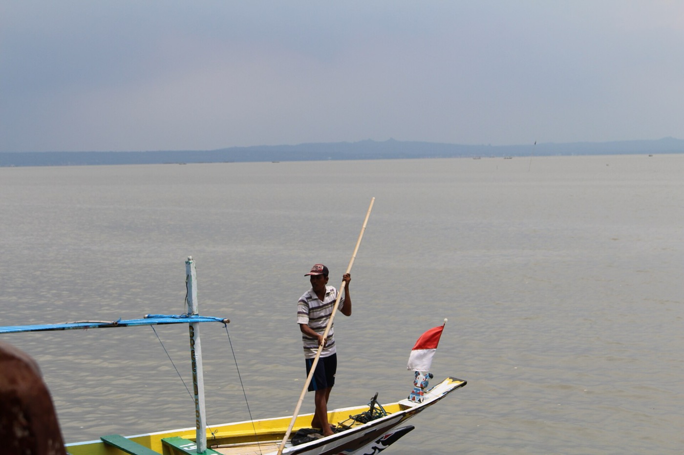 Pantai Kenjeran dengan perahu nelayan dan dermaga kecil.